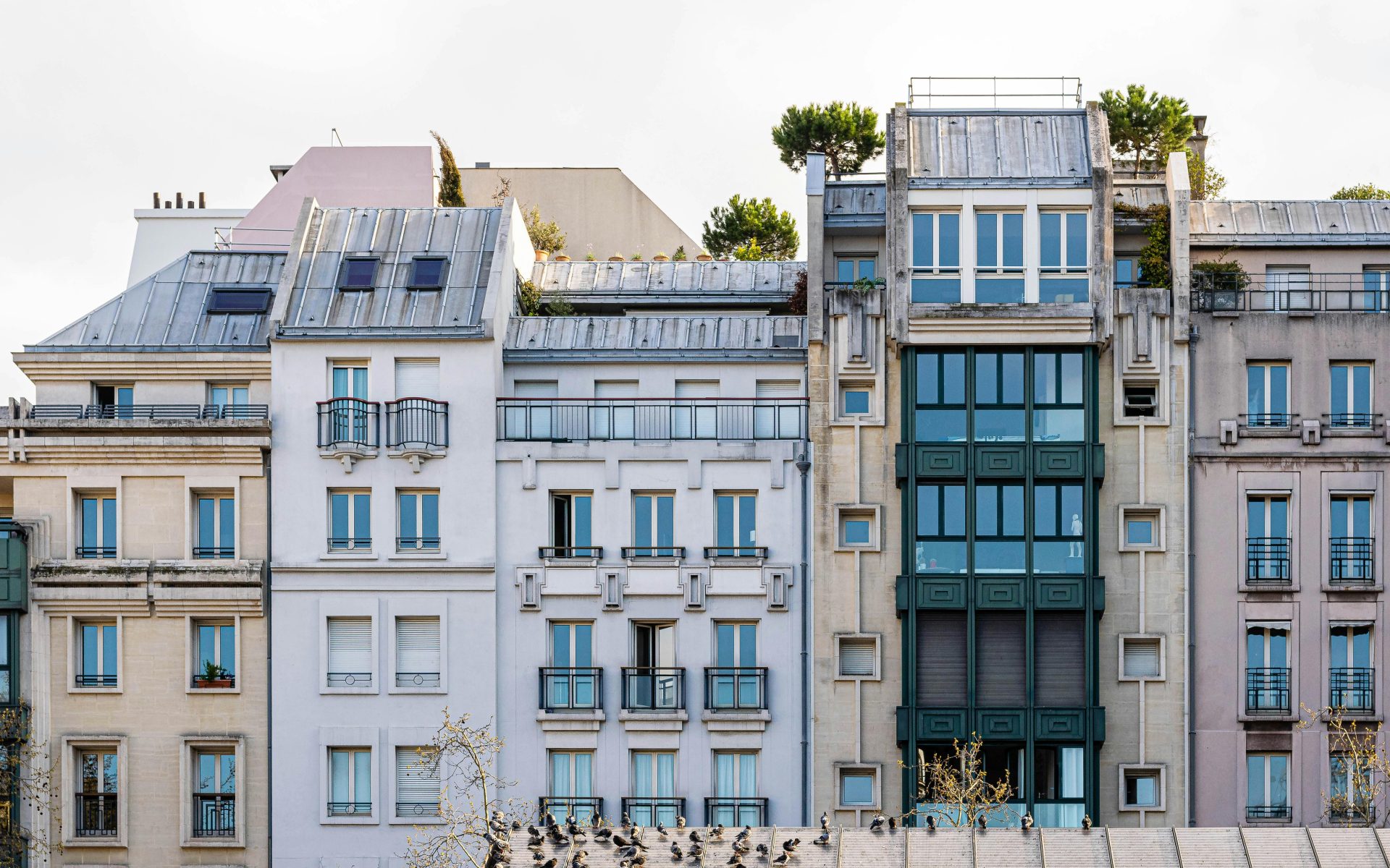 Vue pittoresque de la façade d'un immeuble parisien classique, avec balcons et fenêtres.